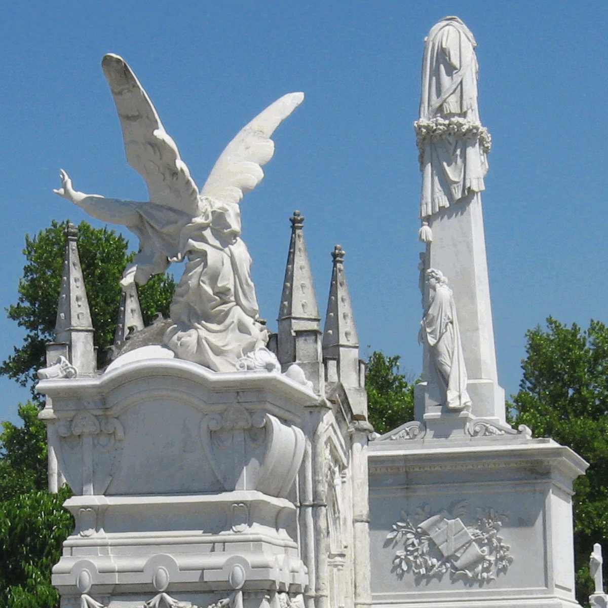 A group of cemetery statues against trees and a blue sky, Havana, Cuba